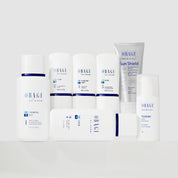 A group of OBAGI MEDICAL skincare products arranged on a white surface against a light gray background. The products include a Control Gel bottle, several white tubes and bottles, a Hyaluader bottle, and a Sun Shield tube.